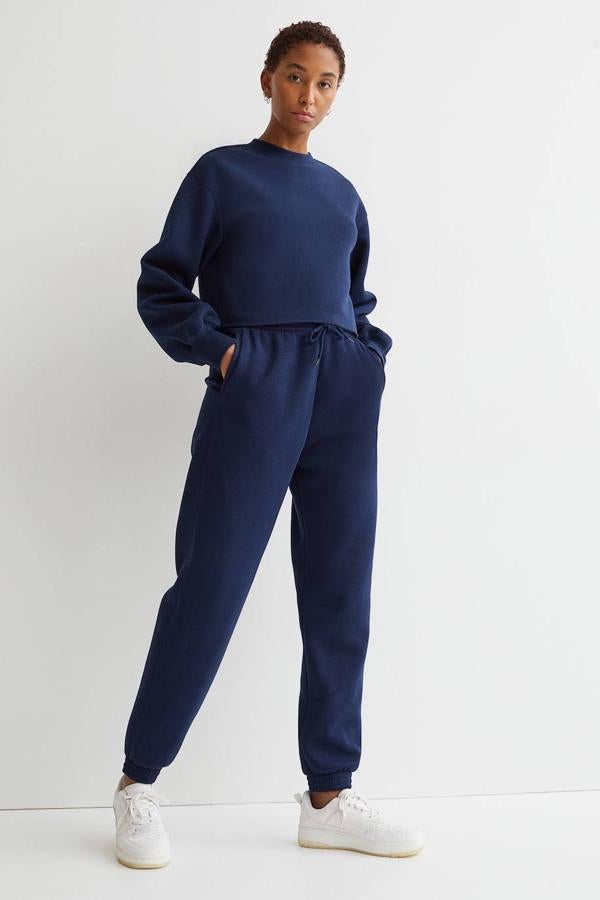 Entre los joggers de H&M hemos escogido uno de talle alto. Lo encontrarás en negro, gris claro jaspeado, blanco, gris oscuro, amarillo claro y azul oscuro. En cuanto a su precio, es de 19,99 €.