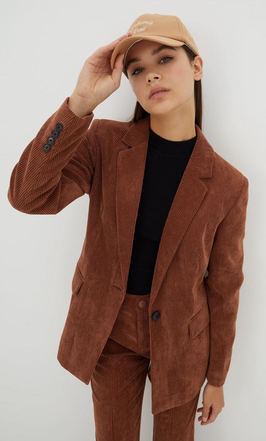 En camel oscuro y confeccionada en pana, esta americana con solapa y mangas largas de Stradivarius viene con hombros marcados, bolsillos delanteros con solapa y cierre frontal de un único botón a contraste. Tiene bajo con abertura en la espalda y cuesta 35,99 euros. 