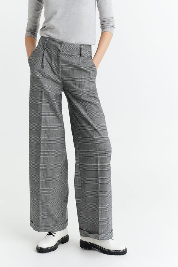 Estampado Príncipe de Gales para estos bonitos pantalones de pernera ancha con bajo recogido, pinzas delanteras y cierre de cremallera y botón que cuestan 25,99 euros.