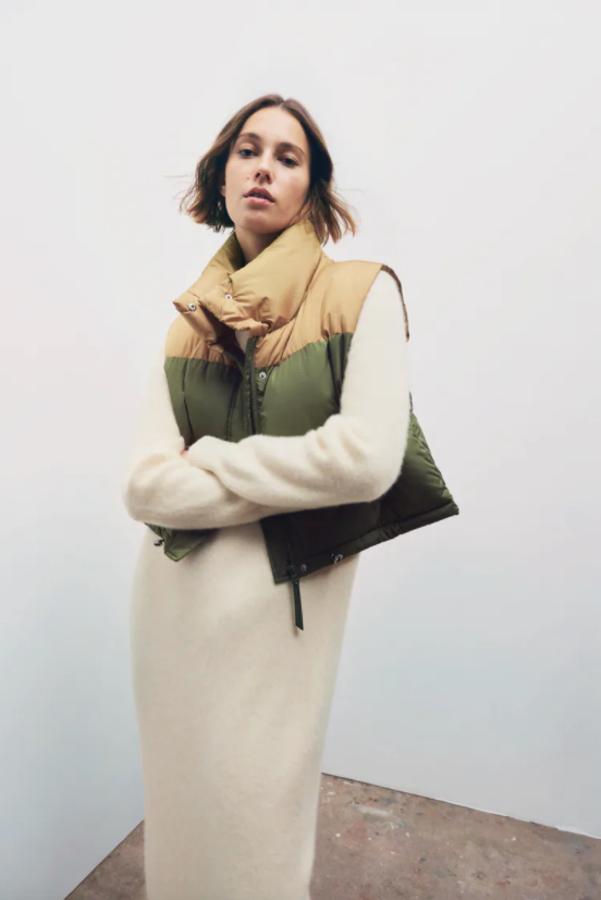 Con hombros y cuello subido en color beige y cuerpo en caqui, este chaleco acolchado de diseño cropped con bajo acabado con cordones elásticos y cierre frontal con cremallera y botones a presión ocultos. Cuesta 25,95 euros.