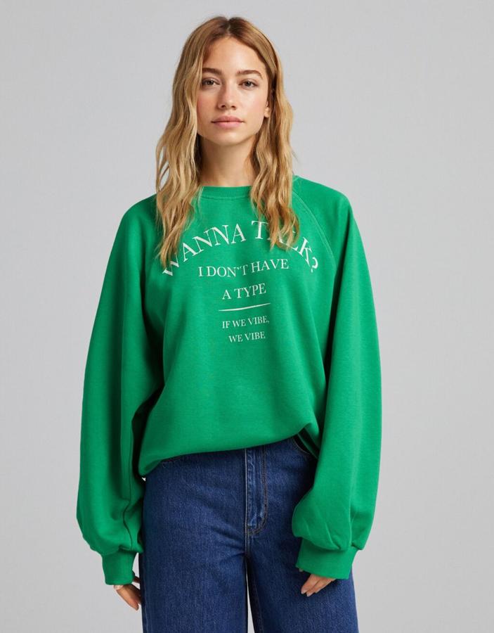 Con print frontal a contraste en blanco, esta sudadera verde de diseño oversize de Bershka con cuello redondo cuesta 17,99 euros. 