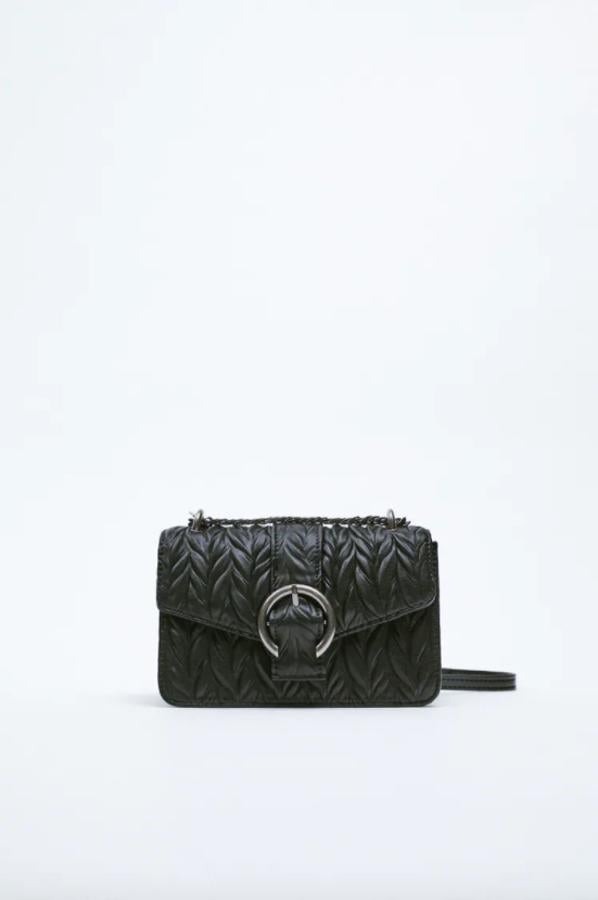 En formato bandolera estilo rock, con detalle de hebilla, interior forrado dividido en dos compartimentos y asa de cadena metálica en función bandolera es de Zara y cuesta 29,95 euros. 