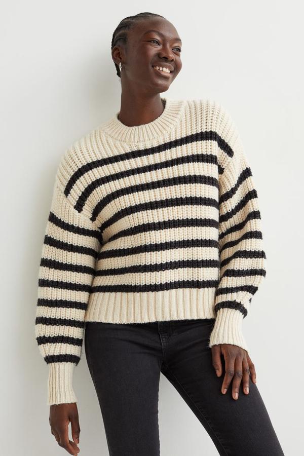 En punto suave con diseño de hombros caídos y ribete de canalé en cuello, puños y bajo, este jersey en beige con rayas en azul marino tiene un precio de 24,99 euros. 