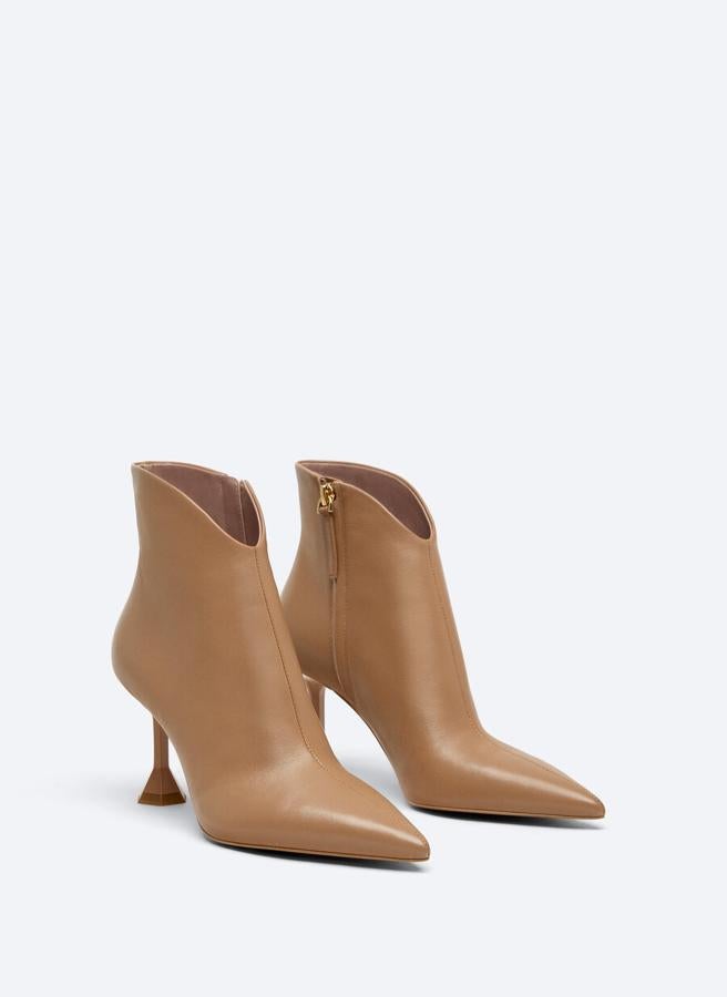 En color arena y con tacones geométricos pintados, estos botines de diseño acabado en punta y con formas redondeadas en el tobillo tienen un precio de 119 euros y están disponibles entre los números 36 y 41. 