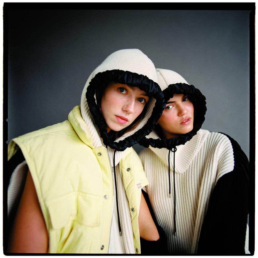 Ambas modelos con jerseys sin mangas, con bolsillos y capucha, de Louis Vuitton. La modelo de la izquierda lleva también chaleco con forro polar, de la misma marca.