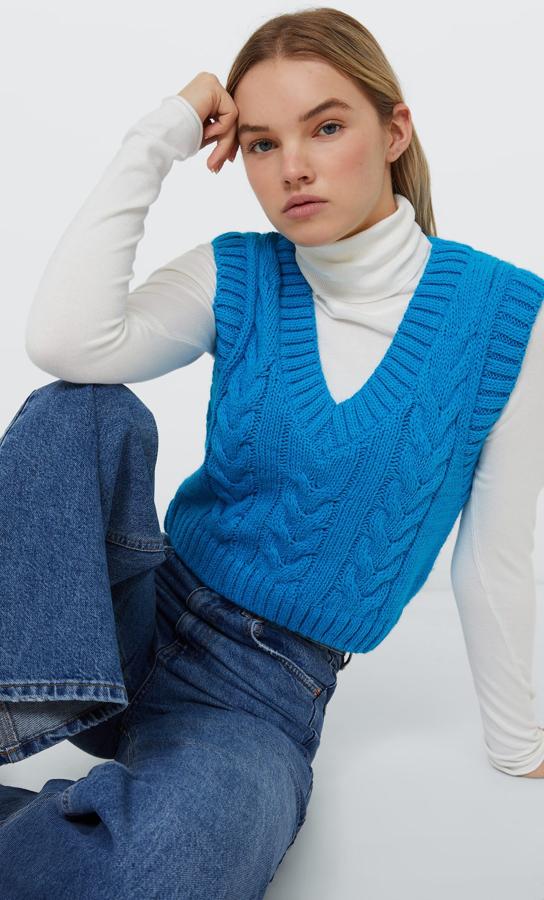 Diseño trenzado y acabados acanalados para este chaleco de punto de Stradivarius con escote de pico y manga sisa en color azul que tiene un precio de 19,99 euros. 