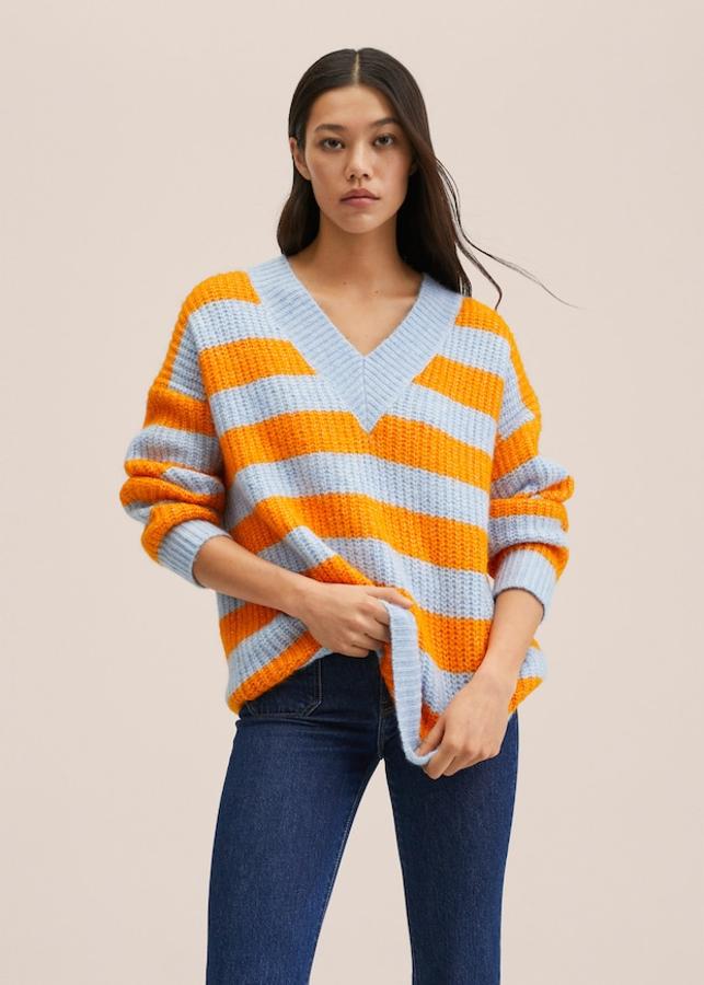 Diseño oversize para este jersey de rayas naranjas y azul celeste confeccionado en punto grueso, con escote de pico y terminaciones de canalé que podemos comprar por 39,99 euros. 