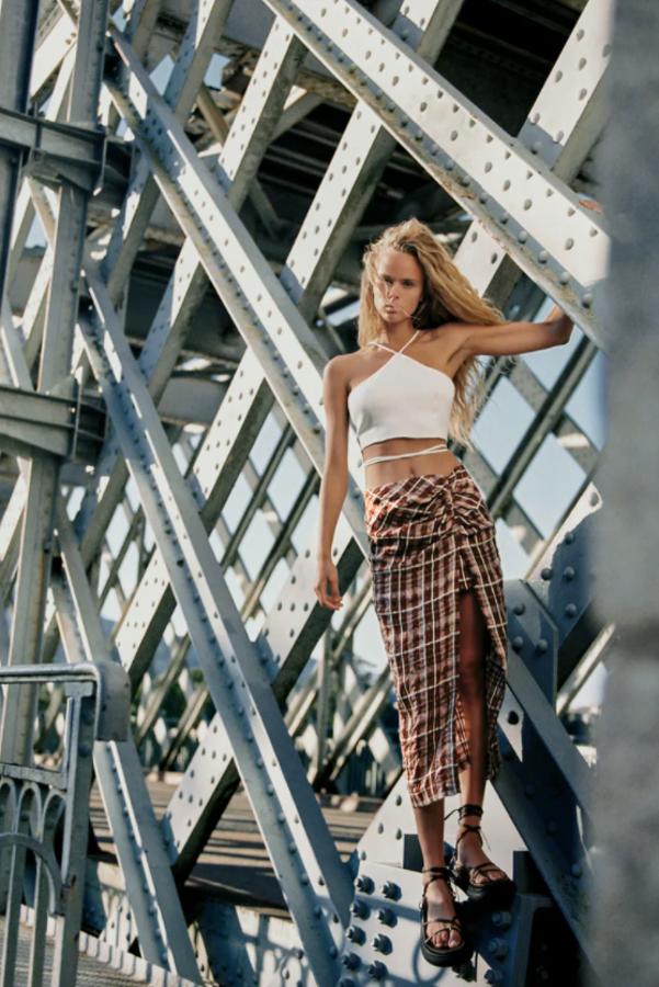 Estampado de cuadros en tonos marrones y crudos para esta falda midi de tiro alto de Zara con bajo con abertura lateral y detalle de frunce en delantero. De 25,95 euros ha pasado a costar 7,99 euros y está disponible entre las tallas XS y XL. 