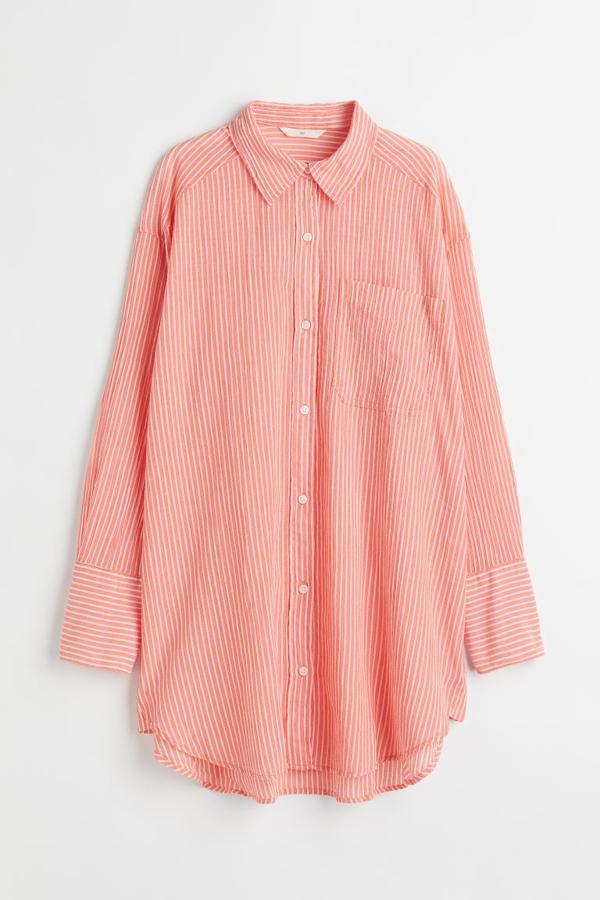 Estampado de rayas blancas sobre fondo en naranja claro para esta camisa oversize de H&M confeccionada en algodón que ciene con cuello clásico, bolsillo de plastrón en la pechera y diseño de hombros caídos. Con bajo ligeramente redondeado y asimétrico, tiene un precio de 24,99 euros y está disponible entre las tallas XS y XXL. 