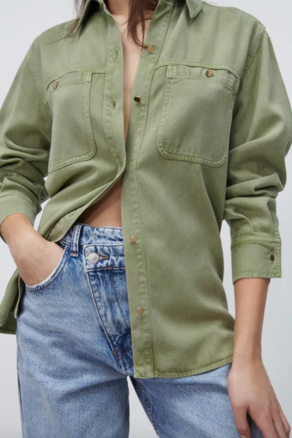 En caqui claro y con escote de pico, esta camisa oversize de Zara con bolsillos de plastrón con botones en la pechera viene con cuello de solapa y cierre frontal de botones metálicos. Tiene un precio de 25,95 euros y está disponible entre las tallas XS y XL. 