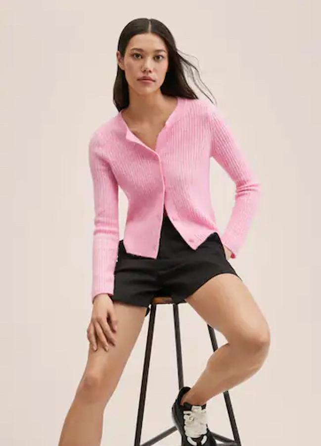 Cuello redondo y cierre frontal de botones a tono para este cárdigan de diseño recto cropped en color rosa chicle que está confeccionado en punto de canalé y solo se vende en la web de la firma por 25,99 euros. 