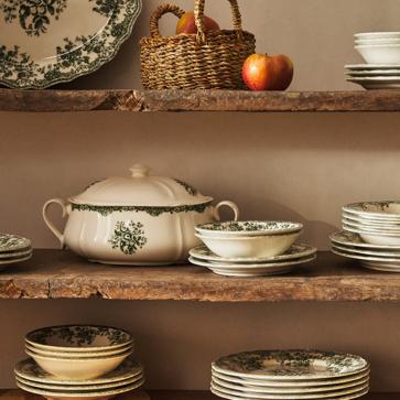 Imagen secundaria 1 - El mantel de lino con estampado de rayas en tonos tierra cuesta 25.99 euros en Zara Home. La vajilla de loza pintada, desde 4.99 euros la pieza, el mismo precio de las servilletas bordadas personalizadas.