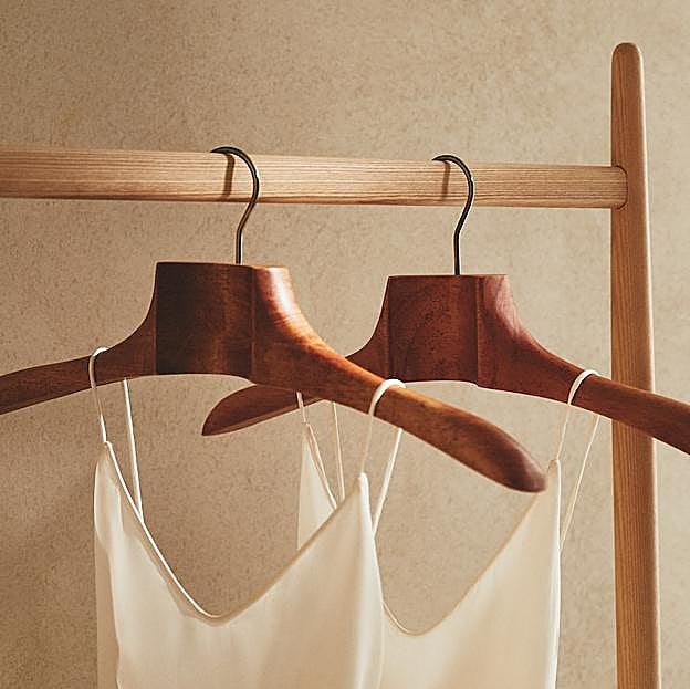 Imagen principal - Las perchas de madera y las doradas cuestan 12.99 euros; y las plegables, 9.99 euros en Zara Home.