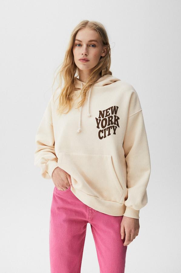 De venta exclusiva en la web de Pull&Bear, esta sudadera en color beige, con gráfico frontal en la pechera, que se repite en la espalda, capucha y bolsillo de canguro, tiene un precio de 25,99 euros. 