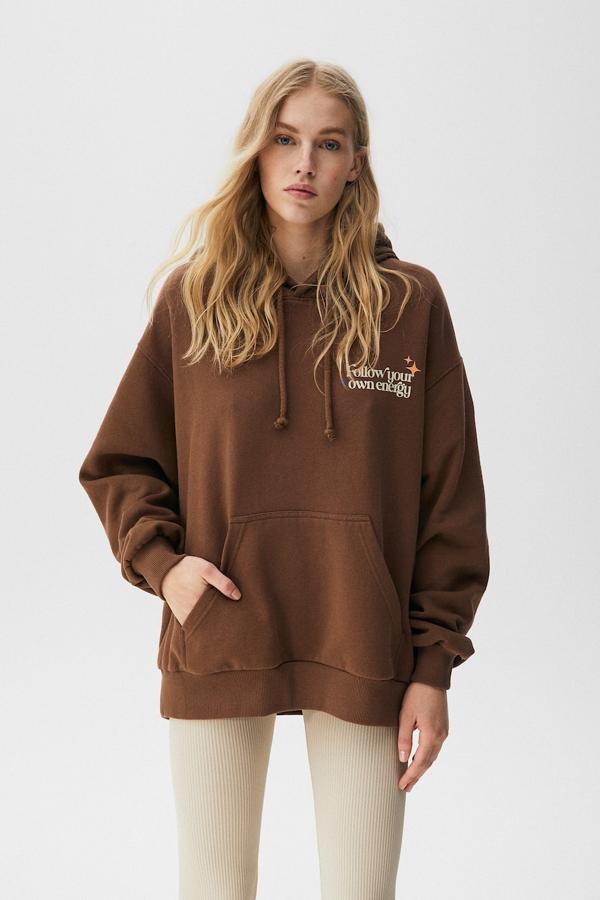En marrón chocolate, con gráfico que ocupa la espalda en beige y otro en la pechera, esta sudadera de venta exclusiva en la web de Pull& Bear, con capucha y bolsillo canguro podemos comprarla por 25,99 euros.