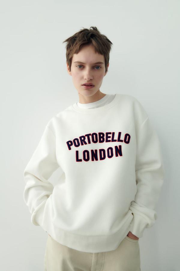 Cuello redondo y mangas largas para esta sudadera en blanco roto de Zara que tiene gráfico delantero combinado a contraste. Podemos encontrarla también en color lima con texto en blanco y ambas cuestan 19,95 euros. 