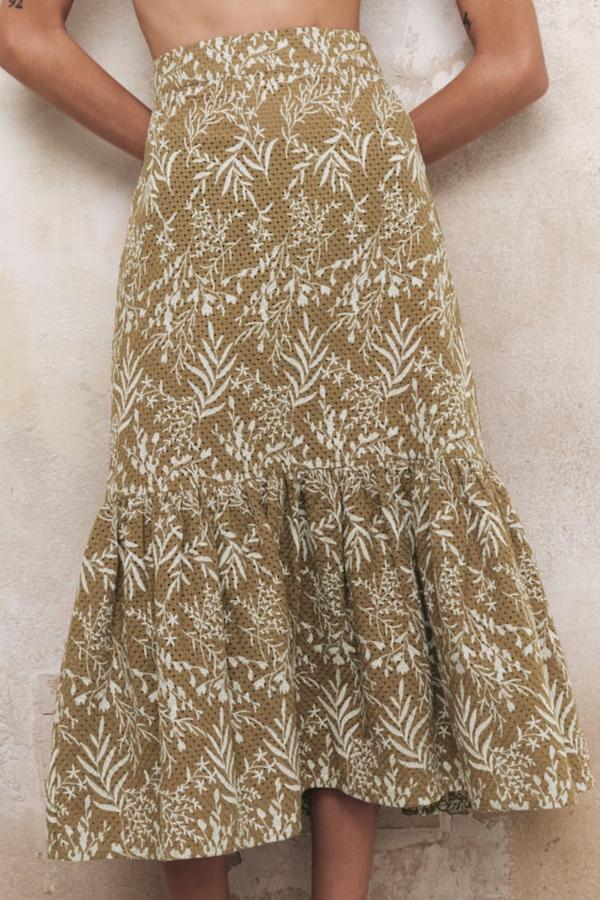 Estampado vegetal en color blanco para esta falda midi de Zara de tiro alto y color beige que viene con detalle de bordados combinados a contraste y el bajo acabado en volante. Disponible entre las tallas XS y XXL, cuesta 39,95 euros. 