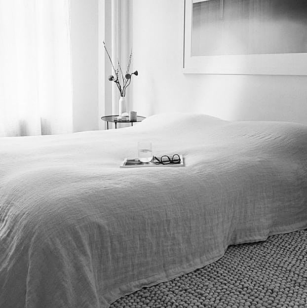 Imagen principal - En Zara Home, la colcha de lino cuesta 139.99 euros, la alfombra de fibras naturales, 399 euros; el jarrón de cerámica 15.99 y el vaso, 4.99 euros. Los platos y cubiertos cuestan 9.99 euros la unidad; y las copas en vidrio espiral en relieve esmaltado, 5.99 euros.