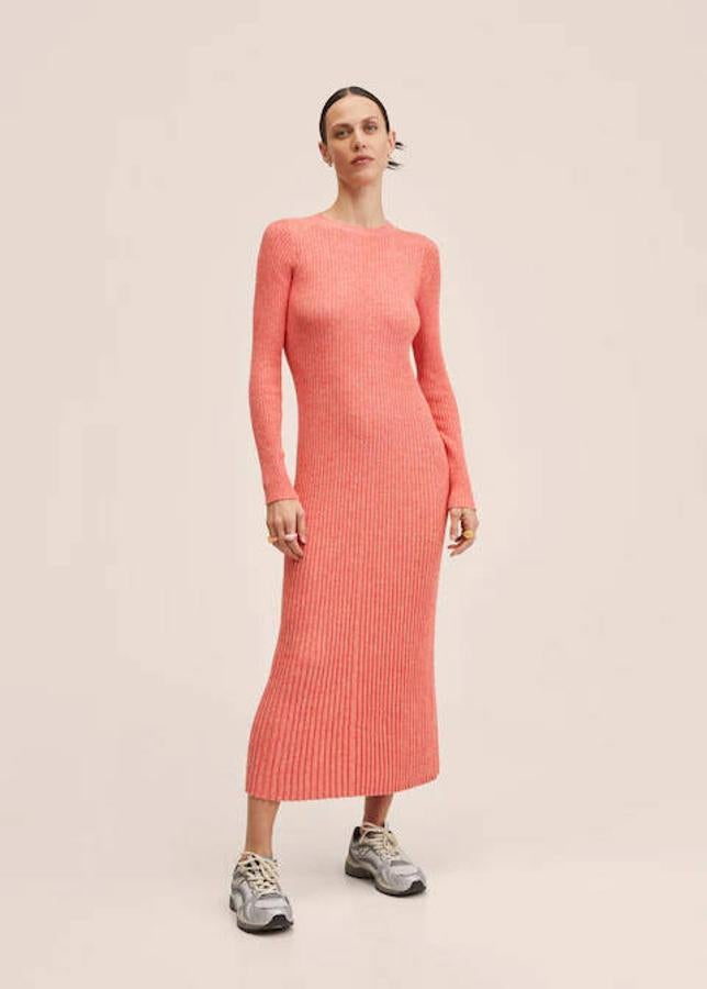 Empezamos con un modelo de Mango: un vestido de punto de canalé en color rojo coral. Tiene un diseño largo y entallado, el cuello redondo y la manga larga. Su precio es de 39,99 euros.
