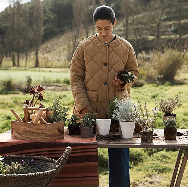 Imagen principal - La mesa con caballete cuesta 349 euros, la colección de jardinería de Zara Home está disponible desde 12.99 euros y el mantel de rayas, 49.99 euros. Las cestas de yute cuestan entre 19.99 y 49.99 euros y la mesa auxiliar, 69.99 euros. 