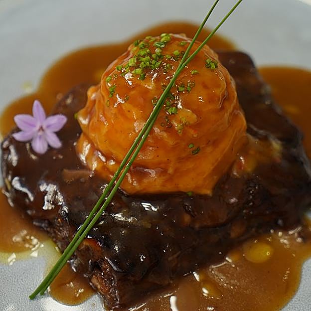 Imagen principal - El brownie de rabo de toro, el local y Pepe Sacristán a los fogones de La Rita.