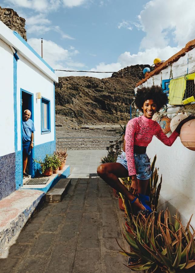 Top de rejilla rosa de Carlos San Juan, shorts vaqueros estampados de Dsquared2 y sandalias con adornos de pedrería, de Duyos.