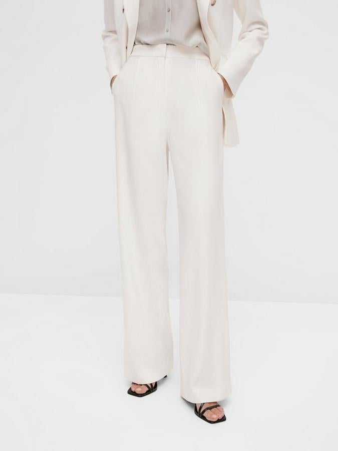 Con detalle de pinzas en el frontal y perneras anchas, estos pantalones de tiro alto, con dos bolsillos laterales y confeccionados en tejido fluido cuestan 69,95 euros y son tan bonitos que han empezado a agotarse en algunas tallas.