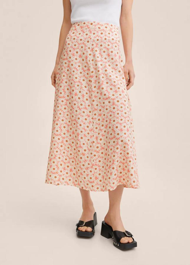 Estampado de margaritas blancas y marrones sobre fondo rosa para esta falda de Mango con diseño evasé y tiro medio confeccionada en tejido fluido. Cuesta 25,99 euros. 