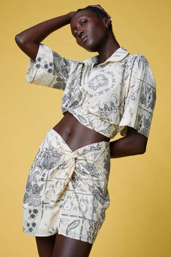 Estampado paisley y de flores sobre fondo crema para esta minifalda de H&M en tejido de algodón, con talle alto y nudo frontal para un efecto drapeado. Sin forro, solo se vende en la web de la firma por 29,99 euros. 