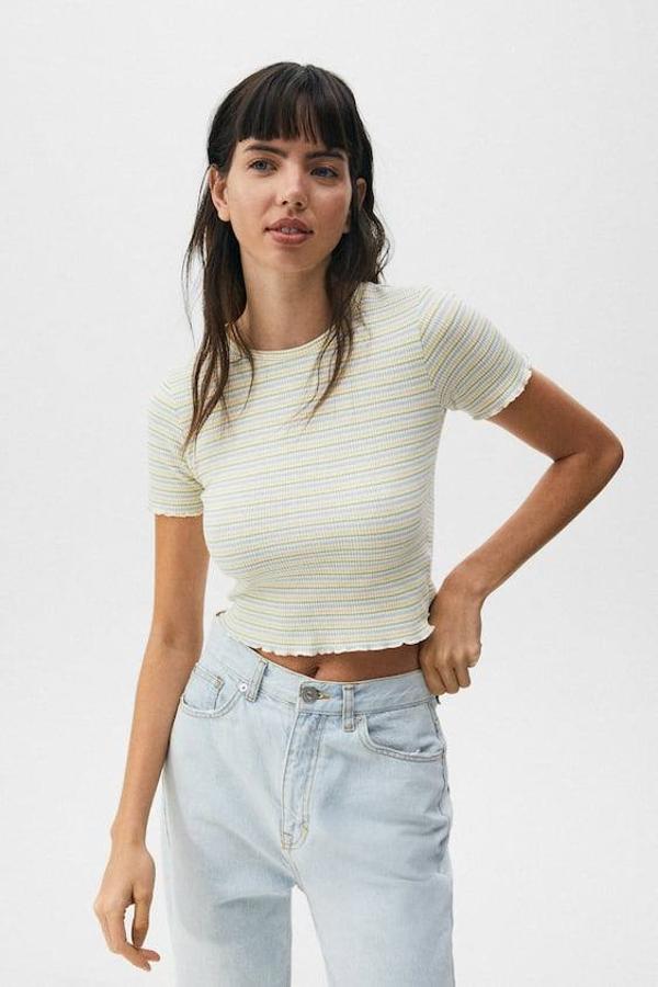Para darle un toque rejuvenecedor a tu look, te recomendamos un modelo de rayas de Pull&Bear. Tiene un diseño básico y de corte cropped. La puedes comprar por 7,99 euros.