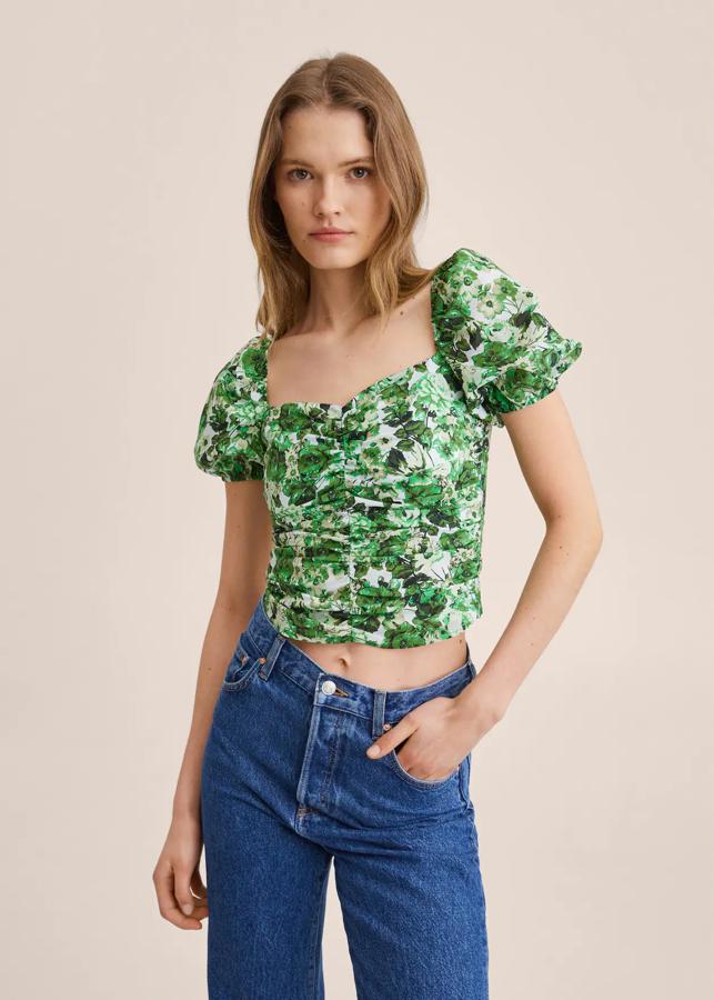 Una de nuestras favoritas es esta preciosa blusa confeccionada en algodón 100% que viene con cuello redondo, diseño cropped y mangas cortas abullonadas con puños elásticos. Cuesta 29,99 euros. 
