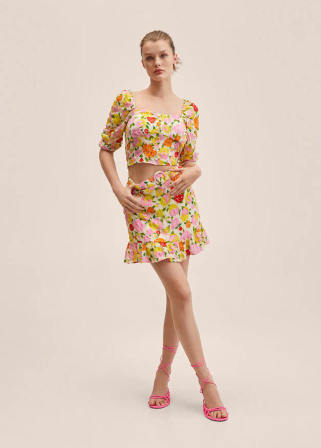 Estampado floral en tonos rosas, rojos y amarillos para esta blusa de Mango en diseño cropped recto, que viene con escote redondo, mangas tres cuartos con puños elásticos y botones decorativos. Con goma elástica tipo nido de abeja en la espalda, cuesta 29,99 euros. 