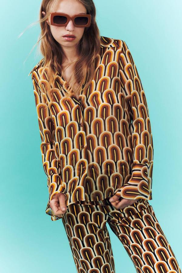 Camisa fluida semitransparente con estampado geométrico retro y manga larga acabada en volante, color marrón. Está en Zara a 29,95 euros.
