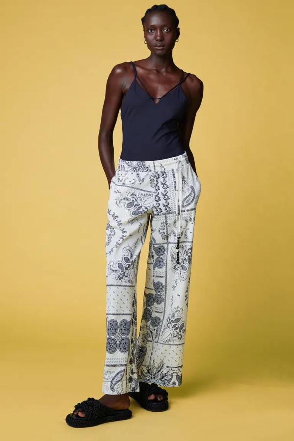 Este pantalón de punto en color crema con estampado paisley en negro es de H&M y viene con perneras amplias rectas, talle alto con elástico revestido y cordón de ajuste con cuentas decorativas en los extremos. De corte relajado, tiene un precio de 34,99 euros. 