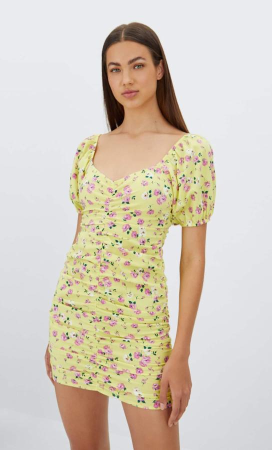 En amarillo pastel, con estampado de rosas en rosa y verde, este vestido fruncido con escopte amplio y mangas cortas abullonadas que tiene detalle de fruncido en el cuerpo es de Stradivaius y cuesta 25,99 euros.