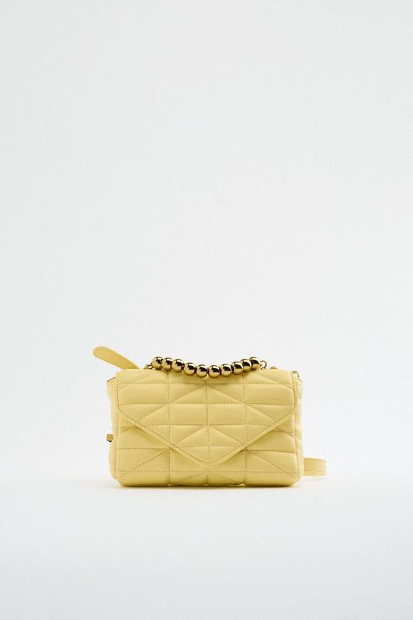 Los complementos son el elemento perfecto para introducir, sin correr demasiados riesgos, este color vitamina. Elige un bolso acolchado con abalorios dorados y llévalo sin miedo. Bolso bandolera de Zara (25,99 euros)