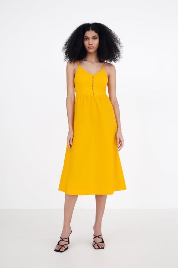 Si no quieres correr demasiados riesgos este vestido será tu aliado. El amarillo casi mostaza cubre este elegante y sencillo vestido midi que te acompañará los próximos meses. Vestido de tirantes de Zara (25,99 euros). 
