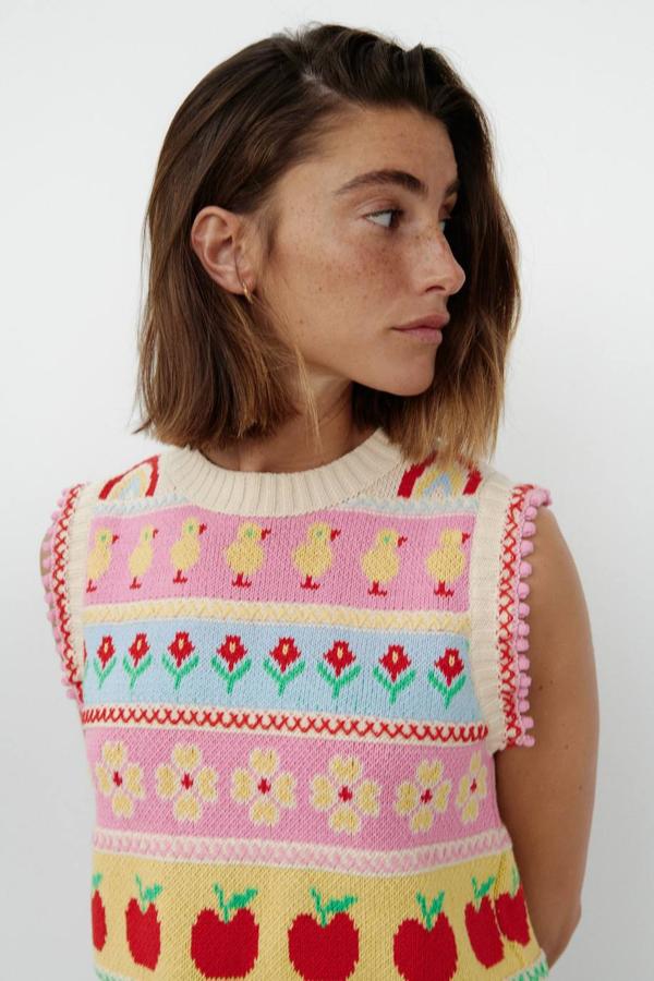 Chaleco de punto jacquard con diferentes estampados multicolor, cuello redondo, manga sisa adornada con pompones y acabados en rib, por un precio de 22,95 euros. Está disponible en Zara de la XS a la L.