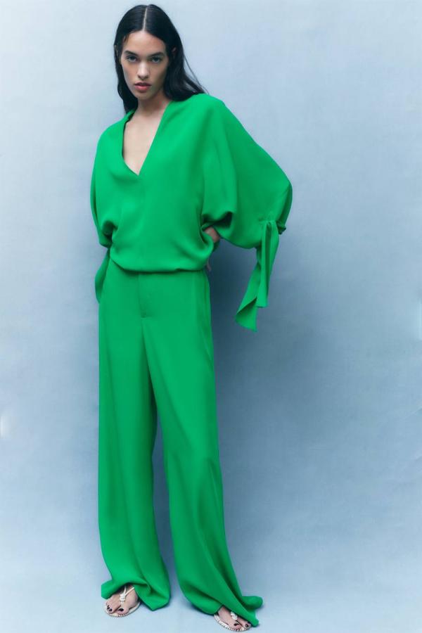 Conjunto de blusa fluida con escote de pico, bajo asimétrico, manga larga con lazada y corte amplio. Y, pantalón palazzo de cintura alta. El precio de las prendas es de 29,95 euros y 35,95 euros, respectivamente y están disponibles en Zara.