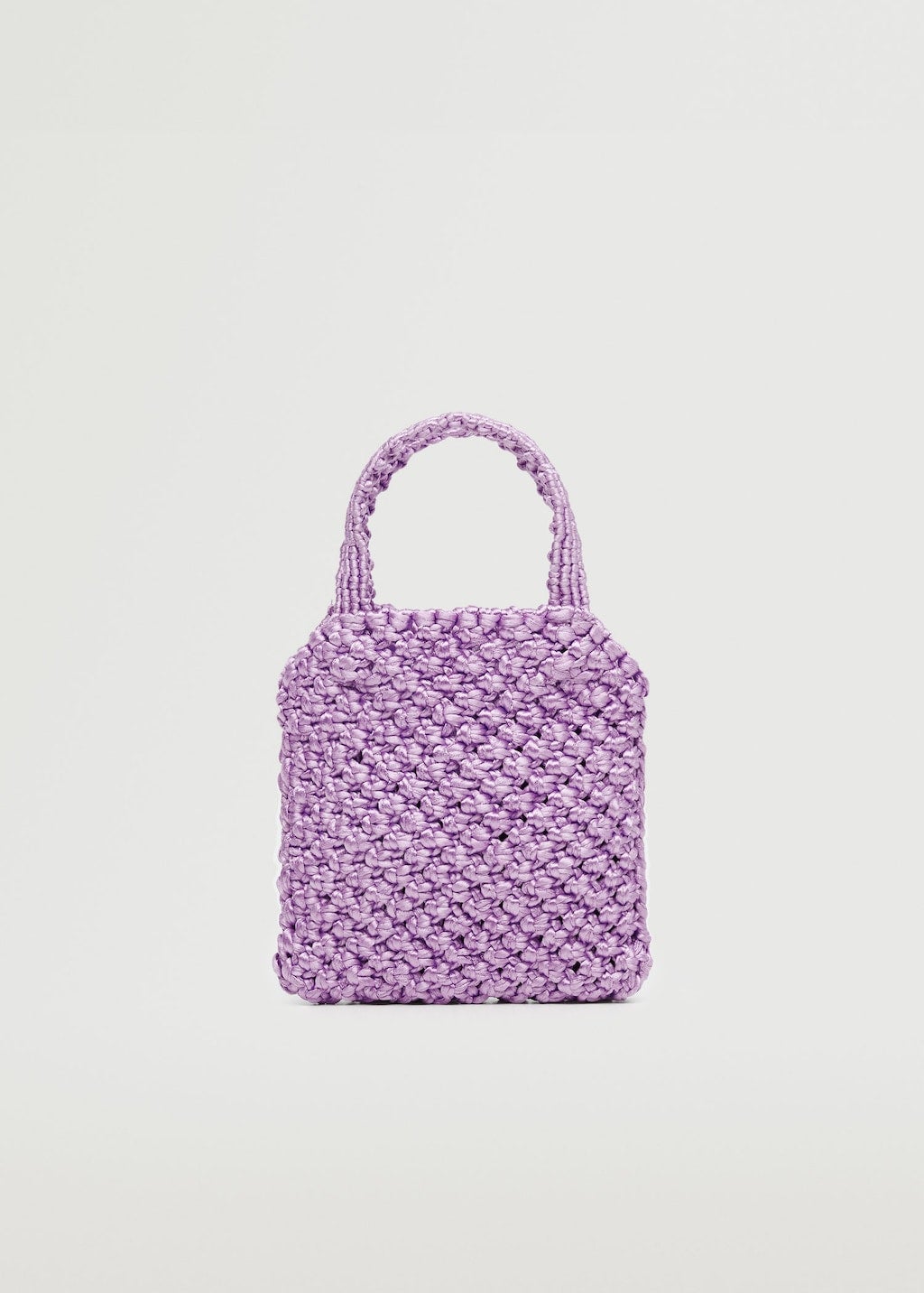 Los bolsos en tamaño mini también saltan a escena en tejidos naturales, como la rafia, o trenzados, como el crochet. El tono malva es perfecto para elevar los looks neutros. Mini bolso de Mango (19,99 euros)