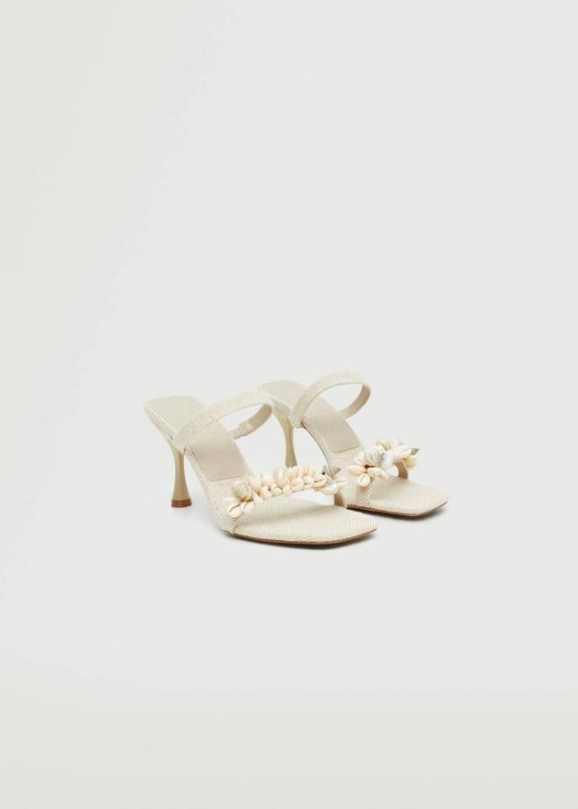 Sandalias de tacón destalonadas con tejido de lino, tiras, punta cuadrada y decoración de conchas, de Mango. Su coste es de 59,95 euros.