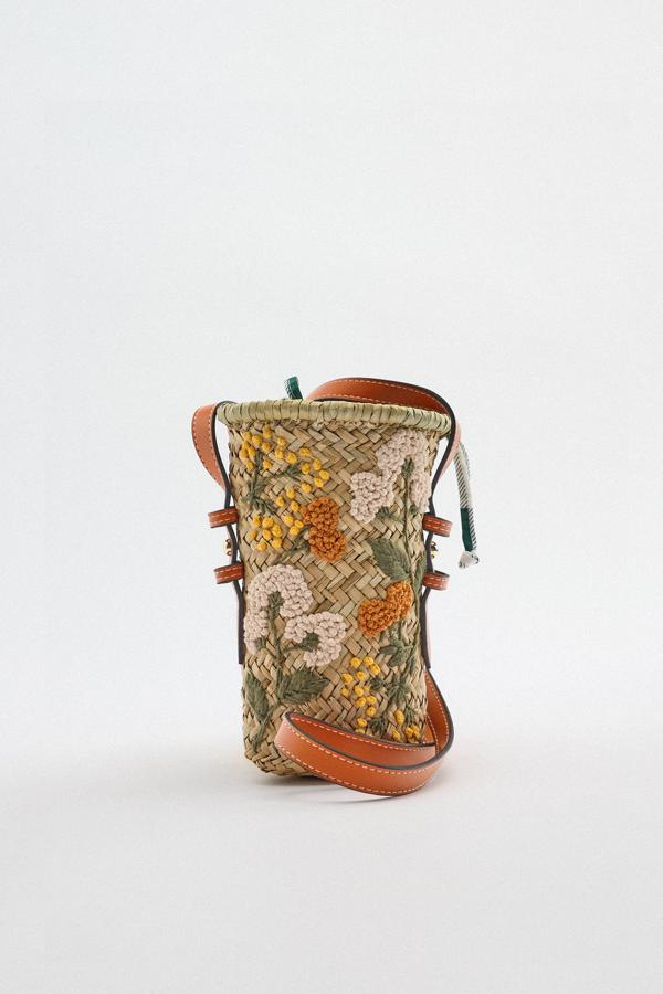 Zara nos presenta una mini bandolera de rafia con motivos florales bordados para aportar mayor un toque diferente a este tipo de bolsos. Además, las asas varían de color dependiendo del modelo: naranja, beige y verde. Cuesta 29,95 €. 