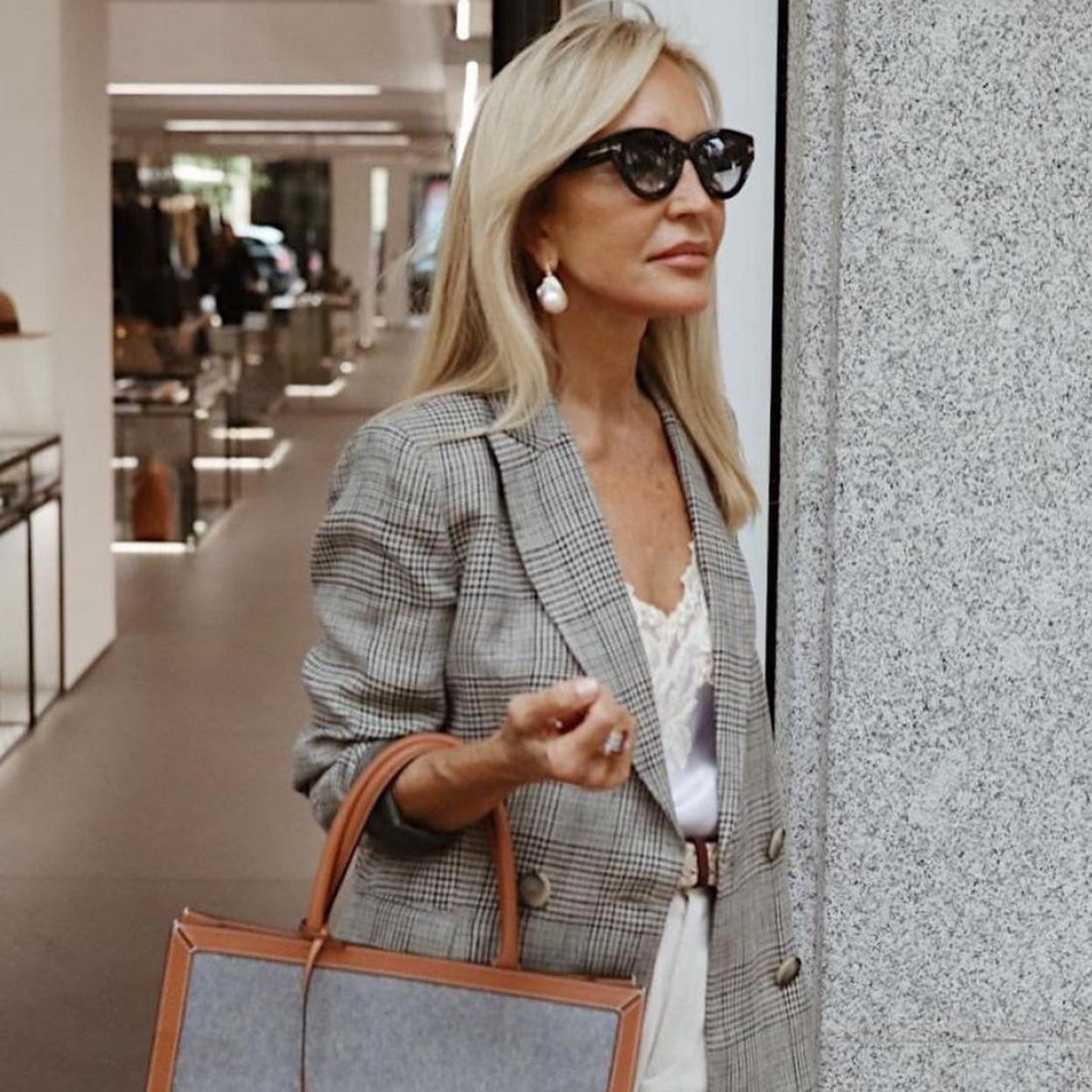Carmen Lomana con un look con blazer de cuadros y pantalones blancos,