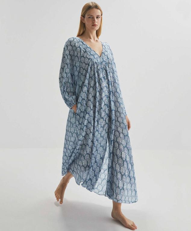 Vestido túnica largo de tejido 100% algodón vaporoso, con estampado en tonos azules, silueta relajada, manga larga terminada en elástico, escote de pico y detalles fruncidos en el pecho, de Oysho. Está disponible por 35,99 euros.