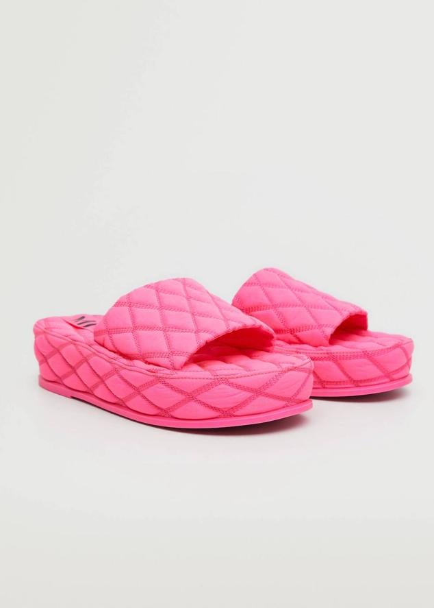 Sandalia destalonada con diseño acolchado y suela de plataforma plana, color rosa flúor, de Mango. Tiene un precio de 49,99 euros.