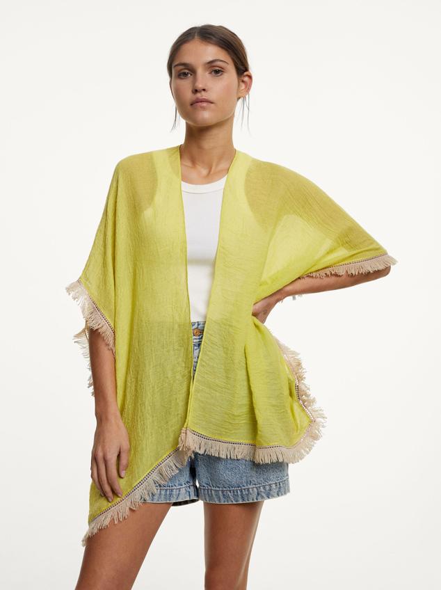Kimono sin mangas en color amarillo y con flecos blancos en los bordes con un toque bohemio. Precio: 19.99 euros.