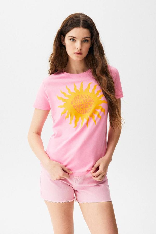 Camiseta de manga corta en rosa chicle con estampado a contraste en forma de sol con texto, de Pull&Bear. La puedes comprar por 5,99 euros.