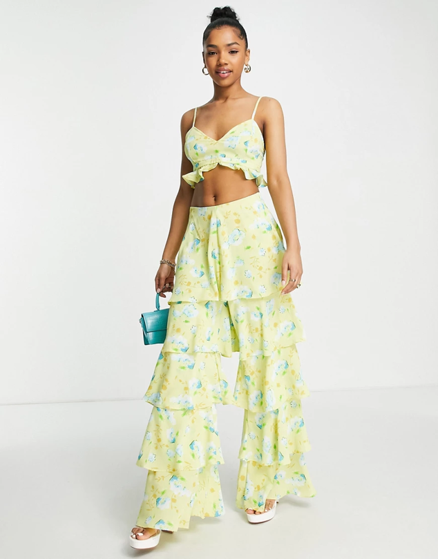 ASOS prefiere unos pantalones extravagantes con volantes y palazzo. Rematándolo con un estampado floral amarillo. Precio: 62,99 €.
