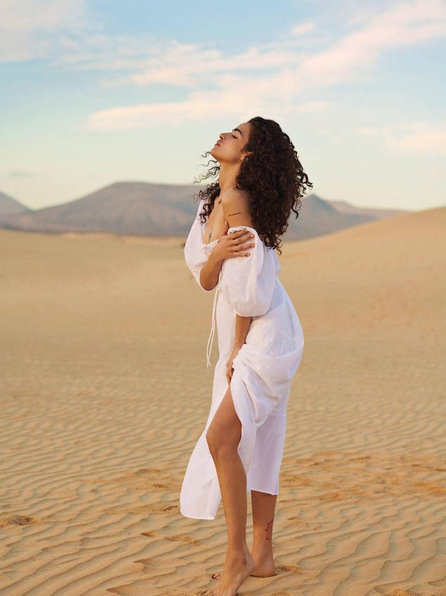 Vestido midi con tejido ligero, detalles bordados, escote cuadrado, manga corta con volumen, detalle de lazada en el pecho y falda amplia con paneles, de Lefties. Tiene un precio de 19,99 euros.