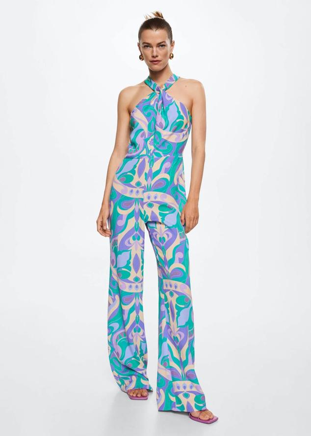 Mono de tejido fluido y ligero con estampado multicolor, tirantes anchos con detalle de nudo en la parte frontal y pernera amplias, de Mango. Su precio es de 49,99 euros.